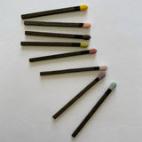 Set of black matchsticks with colorful tips on a white background