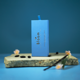 Blue box with 'Bloom' branding on a stone surface against a blue background