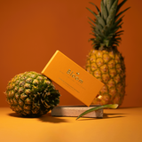 Two pineapples and a box labeled 'Bloom' on an orange background